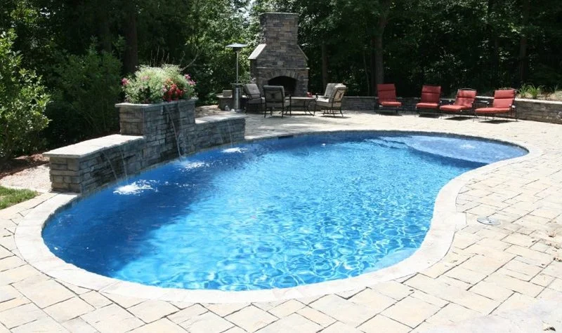 a swimming pool with a fire place in the middle of it.