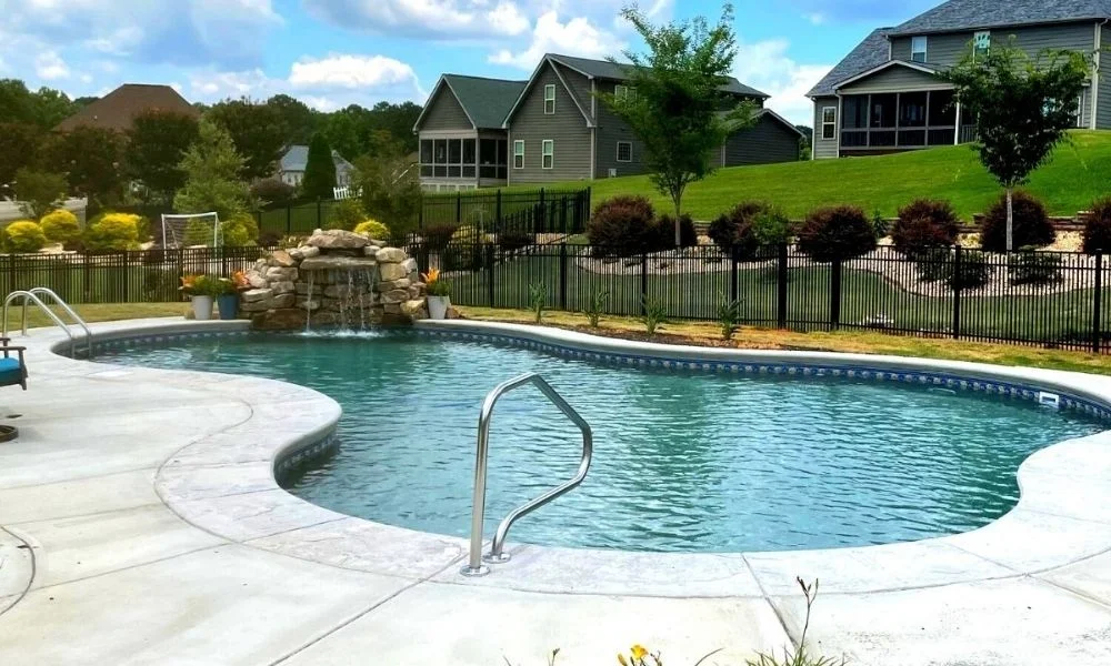 a pool with a waterfall and a fire hydrant.