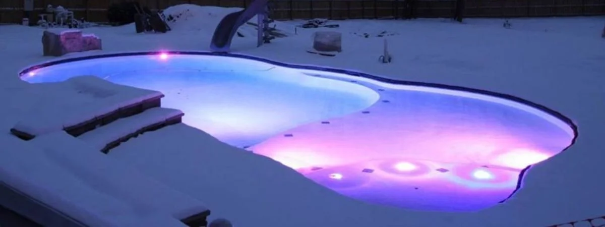 a pool in the middle of a snow covered yard.
