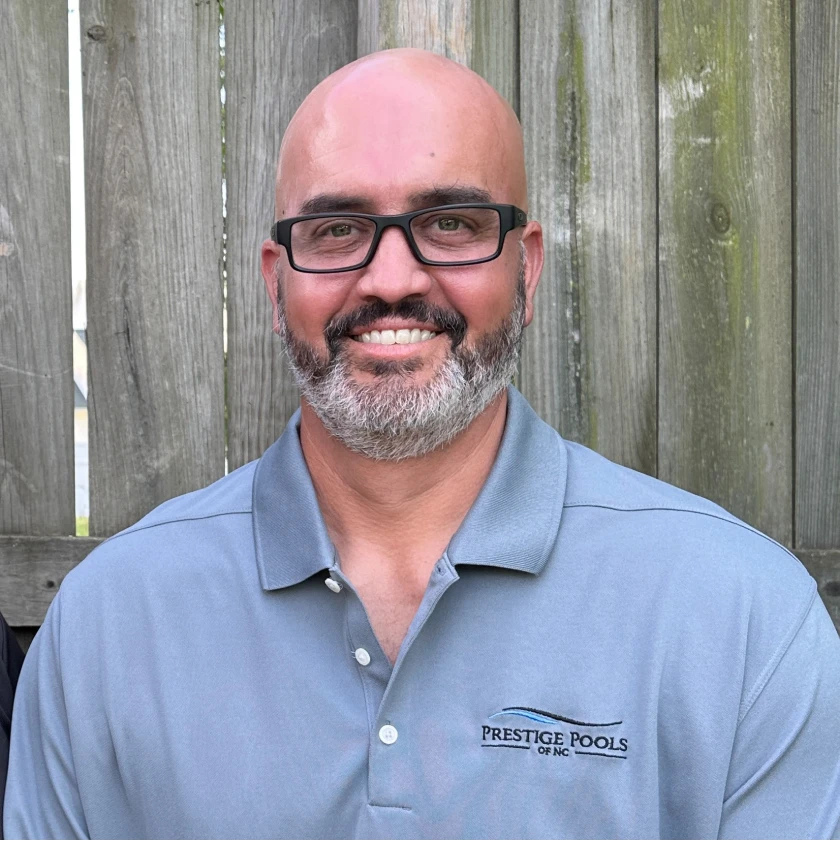 two men smiling in front of a wooden fence. - Prestige Pools - Prestige Pools two men smiling in front of a wooden fence.