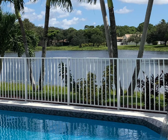 a swimming pool with a fence surrounding it. - Prestige Pools - Prestige Pools a swimming pool with a fence surrounding it.