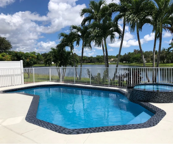 a swimming pool with a fence surrounding it. - Prestige Pools - Prestige Pools a swimming pool with a fence surrounding it.