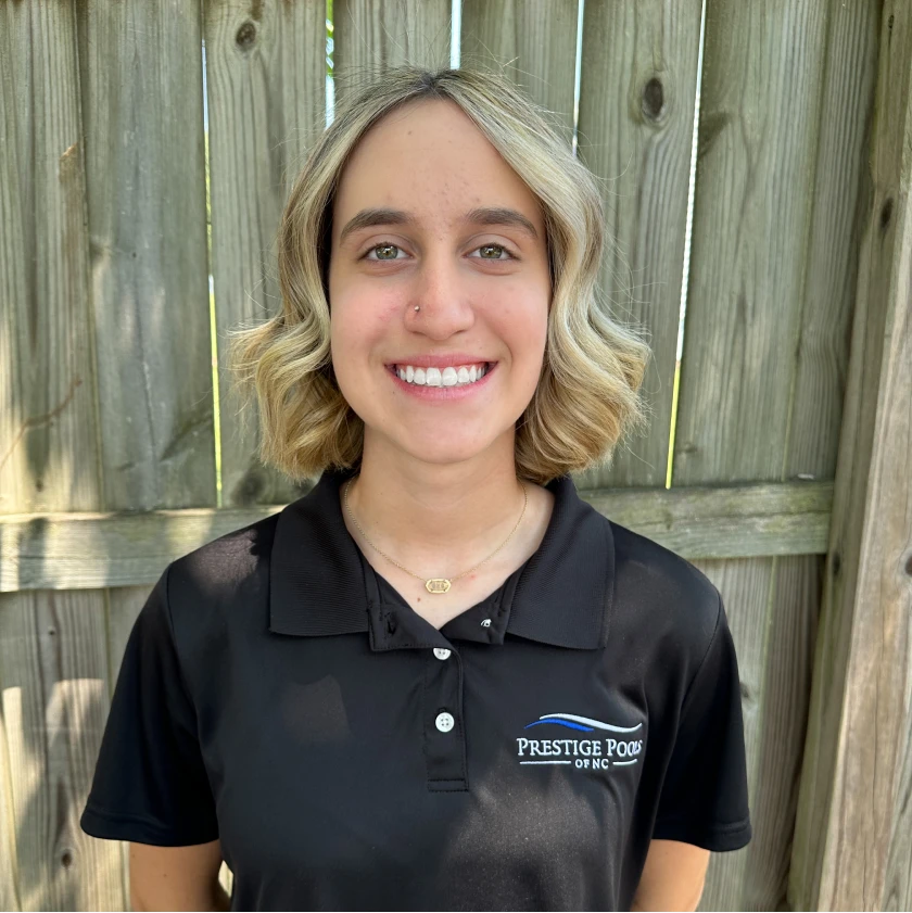 a smiling woman wearing a black polo shirt. - Prestige Pools - Prestige Pools a smiling woman wearing a black polo shirt.