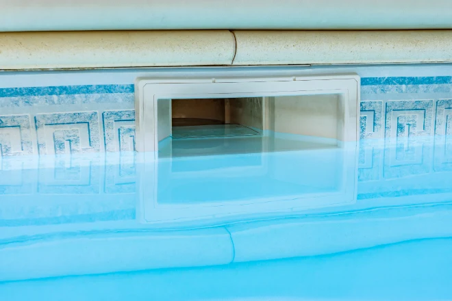 A swimming pool with a hole in the bottom. - Prestige Pools A close up of the intake for an automatic pool skimmer system