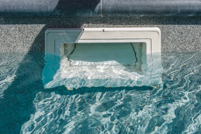 A small hole in the side of a swimming pool. - Prestige Pools A close up of a weir door